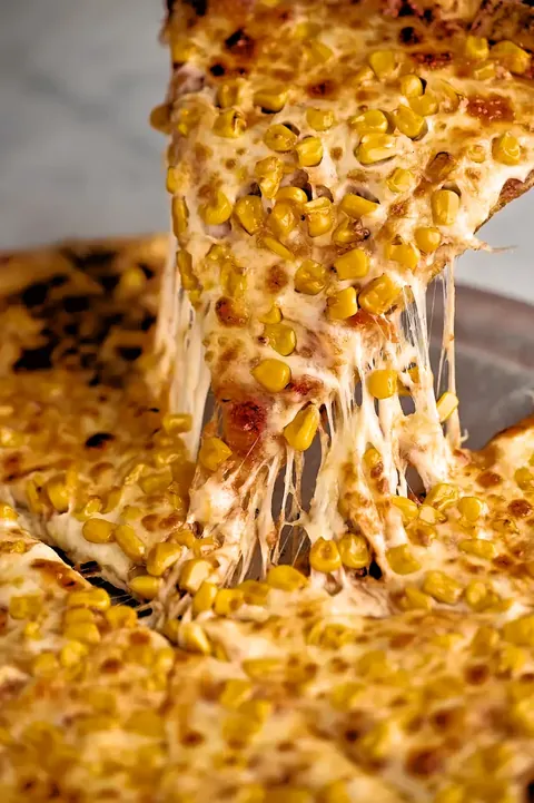 Porción de pizza de maíz con el queso estirado